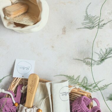 Sustainable zero waste products in a basket with greenery on a white background.